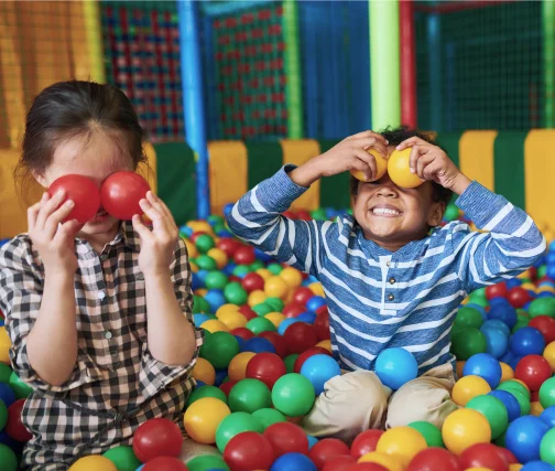 Enfants qui jouent dans une aire de jeux couverte Fun City – structures gonflables, toboggans et trampolines – activité familiale recommandée par Parent Cool.