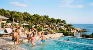Vue ensoleillée d'un camping familial avec piscine sur la Côte Bleue près de la mer.