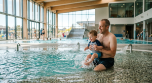 Une famille joyeuse profite du bassin ludique intérieur du centre aquatique Océanide, avec des jeux d'eau et une lumière naturelle chaleureuse.